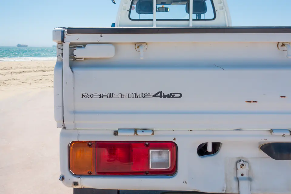 4WD badge and tail lights on the tailgate of a white Honda Acty Kei Truck