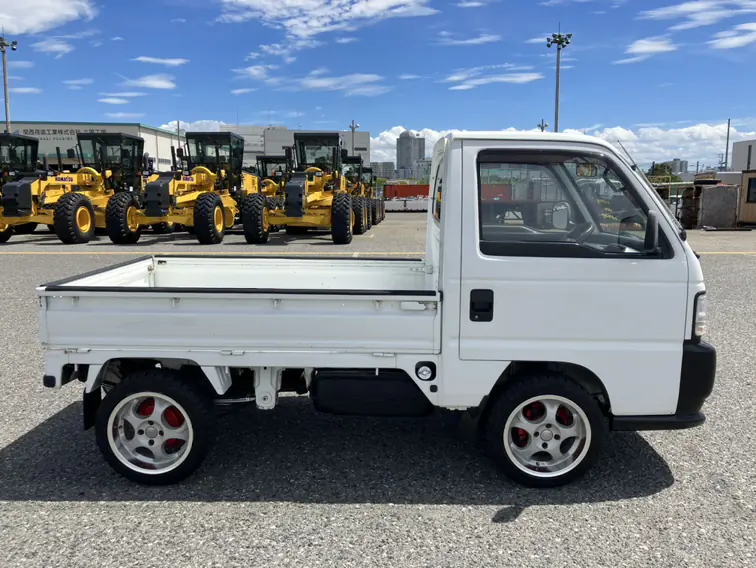White Honda Acty Kei Truck at a Japanese port with wheel loaders in the background